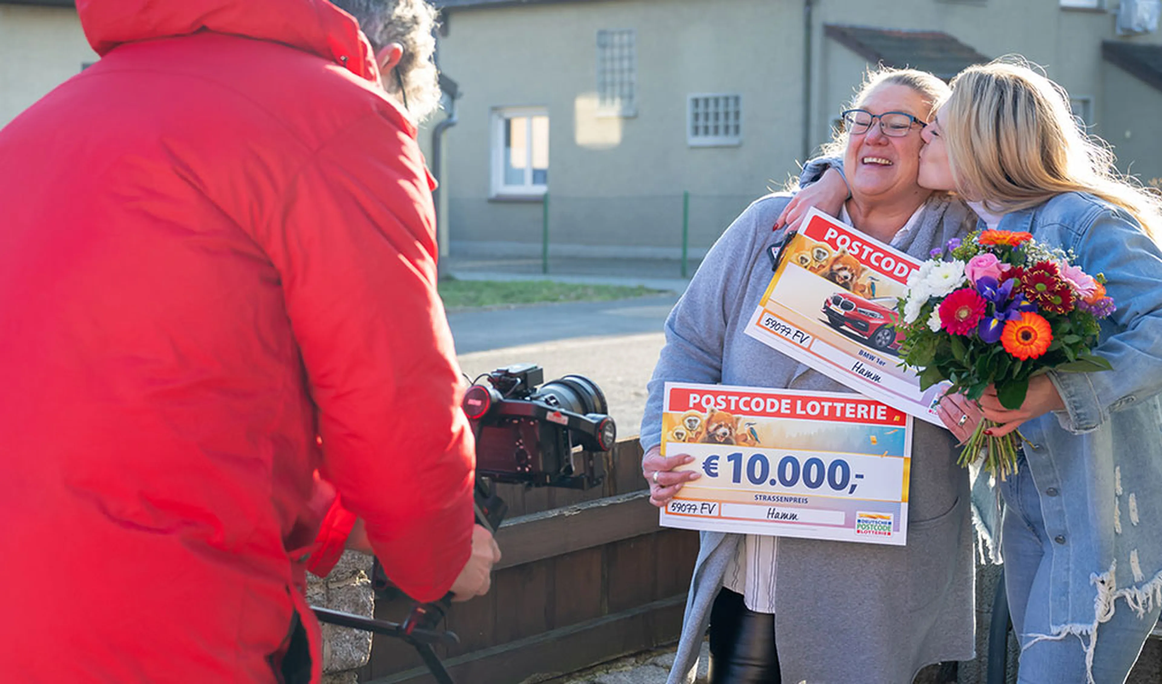 Gewinnerin freut sich über 10000 Euro und einen BMW 1er