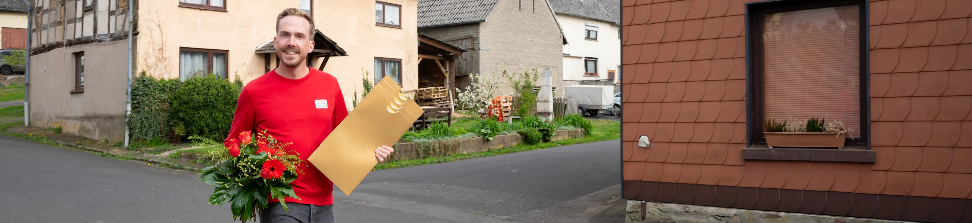 Der Moderator der Deutschen Postcode Lotterie überbringt den Straßenpreis