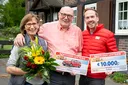 Der Straßenpreis Gewinner in Dortmund freut sich über 10.000 Euro und einen BMW 1er von der Deutschen Postcode Lotterie