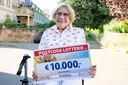 Die Gewinnerin beim Straßenpreis der Deutschen Postcode Lotterie freut sich über 10.000 Euro